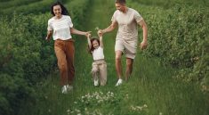 Joyful family enjoying a fun day outdoors in a green field, epitomizing togetherness and happiness.
