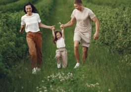 Joyful family enjoying a fun day outdoors in a green field, epitomizing togetherness and happiness.